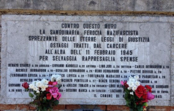 La lapide a ricordo dei 23 partigiani fucilati davanti al cimitero