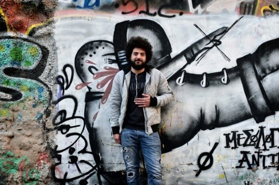 Majd Ahmad, a 26-year old Syrian refugee from Aleppo, poses for a photo at the 'alternative' neighborhood of Exarchia in Athens, home to many Syrian refugees in NGO-leased apartments or in squats run by anarchist movements