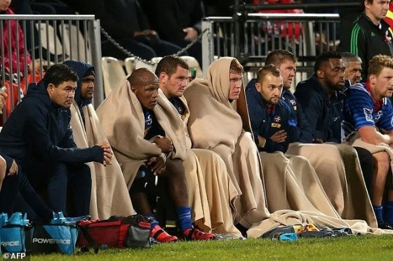 The Western Stormers' players watch from the reserve bench as they try to keep warm during their Super Rugby match against the Canterbury Crusaders, at AMI Stadium in Christchurch, on April 22, 2017