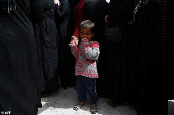 A boy looks on as displaced Syrians from Tabqa and Raqa wait for aid parcels near the northern Syrian village of Jarniyah, on April 6, 2017