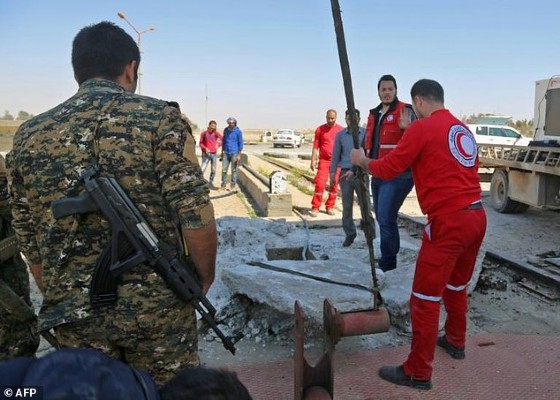 Syrian Arab Red Crescent members and Syrian Democratic Forces inspect the Tabqa dam in March 2017