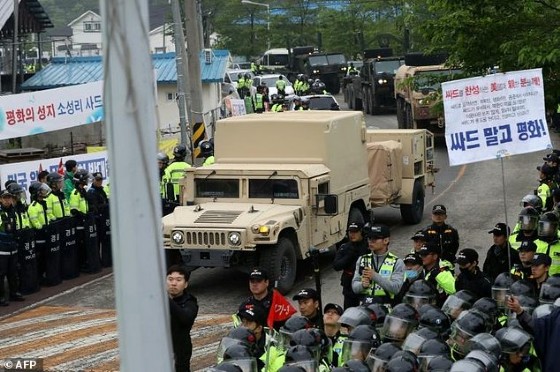 Protesters and police stand by as trailers carrying US THAAD missile defence equipment enter a deployment site in Seongju, South Korea, on April 26, 2017