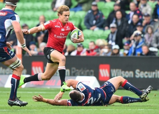 Golden Lions' Andries Coetzee leaps clear of a tackle attempt by James Hanson of the Melbourne Rebels