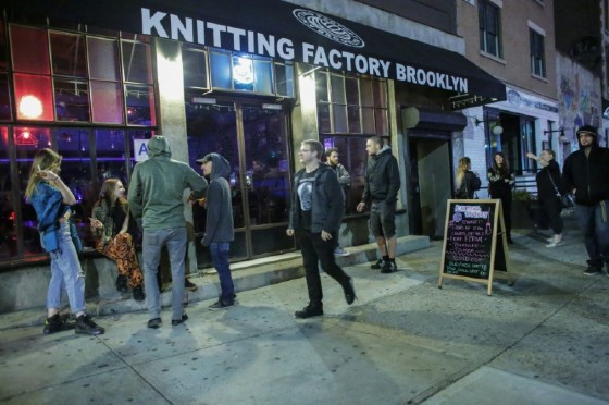People walk past a sign for a Lights Out concert at The Knitting Factory in Brooklyn New York on May 12, 2017