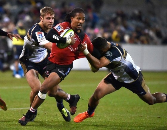Lions' Sylvian Mahuza (C) is tackled by Brumbies' Wharenui Hawera (R) and Kyle Godwin during their Super Rugby match, in Canberra, on May 12, 2017