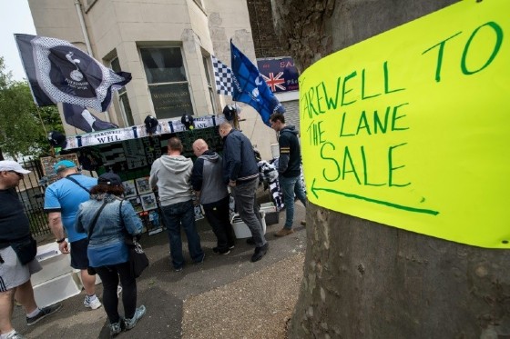 Football fans buy items from a merchandise stall before the English Premier League match between Tottenham Hotspur and Arsenal at White Hart Lane in London, on April 30, 2017