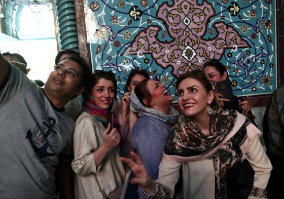 Iranians take a selfie as they queue to vote in presidential elections at a polling station in Tehran on May 19, 2017