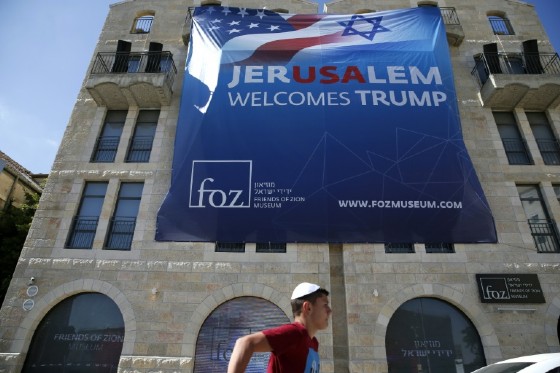 An Israeli youth walks past a poster welcoming and supporting US President Donald Trump in downtown Jerusalem