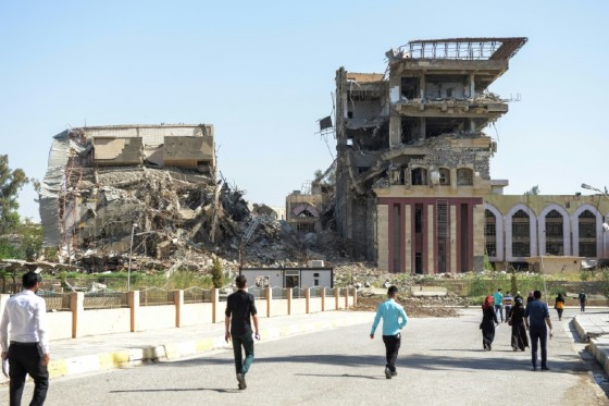 Iraqis walk towards the University of Mosul, where some buildings were destroyed in the fierce battles between Iraqi forces and Islamic State militants