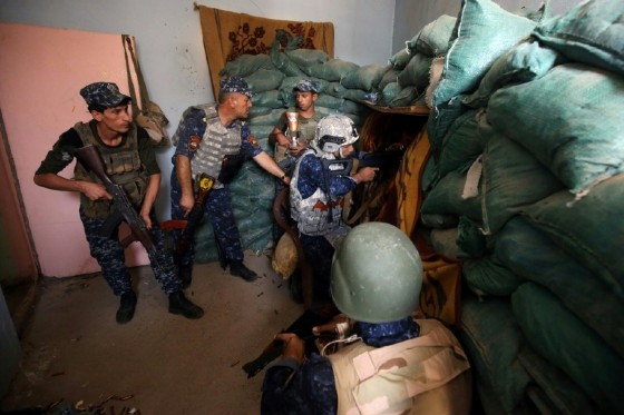 Iraqi forces take positions inside a building as they advance towards Mosul's Old City on June 18, 2017
