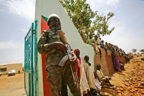 A UN peacekeeper stands guard as crowds of children and villagers gather to welcome Steven Koutsis, the top US envoy in Sudan, in the war-torn town of Golo on June 19, 2017