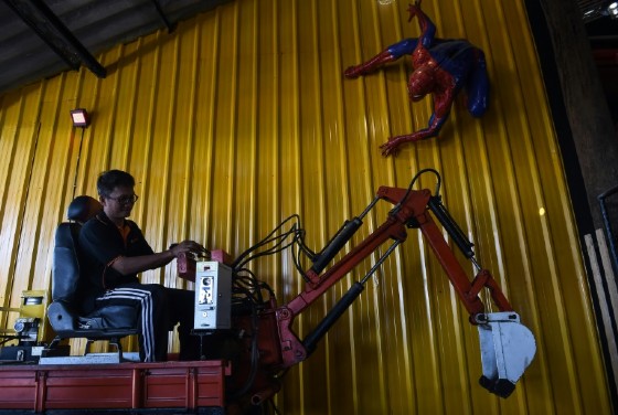 Artist Pairoj Thanomwong operating mechanical toys at Ban Hun Lek, a metalworks shop renowned for giant statues of Transformers, The Hulk and other pop icons