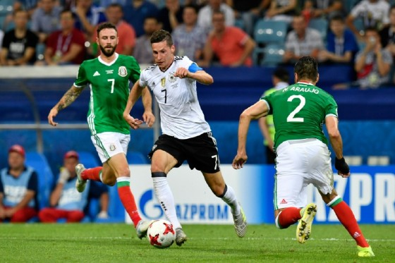Germany's midfielder Julian Draxler (C) fights for the ball with Mexico's midfielder Miguel Layun (L) and Mexico's defender Nestor Araujo during the 2017 Confederations Cup semi-final football match June 29, 2017