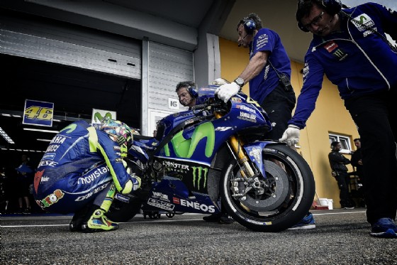 Il Dottore accucciato a fianco della sua Yamaha prima di scendere in pista