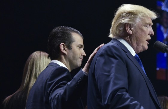 Donald Trump, Jr., (L) as he places a hand on the shoulder of his father Donald Trump, during in a rally on the final night of the 2016 US presidential election