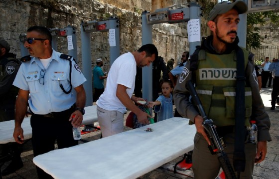 A Palestinian man empties his bag at a recently installed metal detector outside an entrance to the Al-Aqsa mosque compound in Jerusalem's Old City on July 16, 2017, as security forces reopen the ultra-sensitive site following a deadly attack