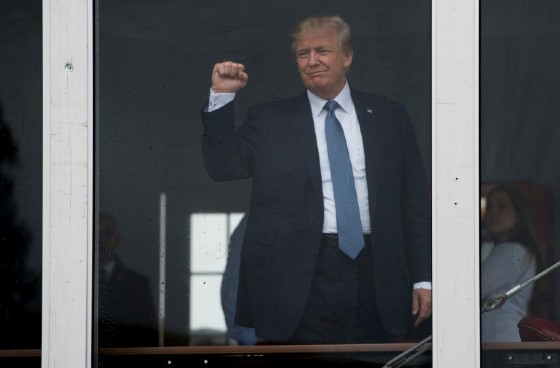 US President Donald Trump salutes wellwishers with a clenched fist at the US Women's Open Golf Championship at Trump National in Bedminister, New Jersey