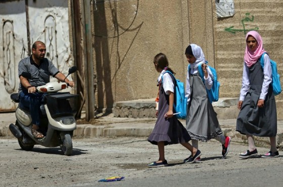 Iraqi girls walk to school in western Mosul on July 27, 2017
