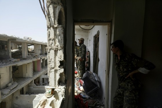 Members of the Syrian Democratic Forces, a US-backed Kurdish-Arab alliance, move through destroyed buildings in Raqa on July 28, 2017, as they battle jihadists in the city