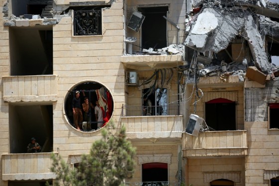 Members of the Syrian Democratic Forces (SDF) take a cigarette break in a destroyed buildings in Raqa on July 28, 2017, as the US-backed alliance fight jihadists in the city