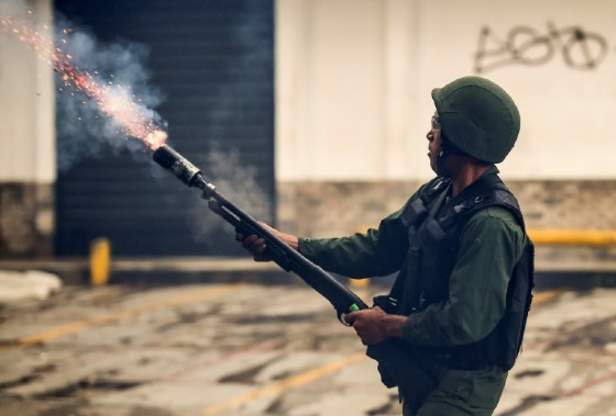 A member of the national guard fires a tear gas grenade during opposition-led clashes in Caracas on July 28