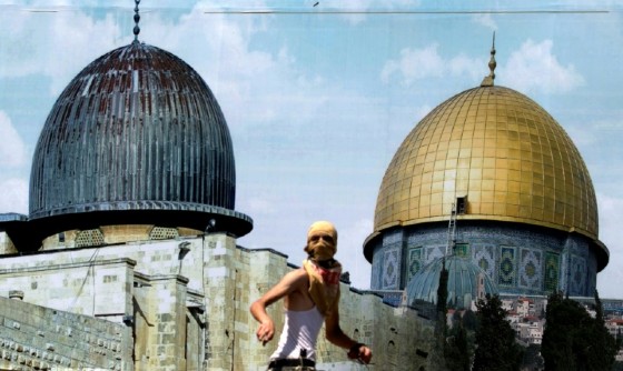 A Palestinian protester stands in front of a mural depicting Jerusalem's golden-topped Dome of the Rock during clashes with Israeli security forces outside the West Bank city of Nablus on July 28, 2017