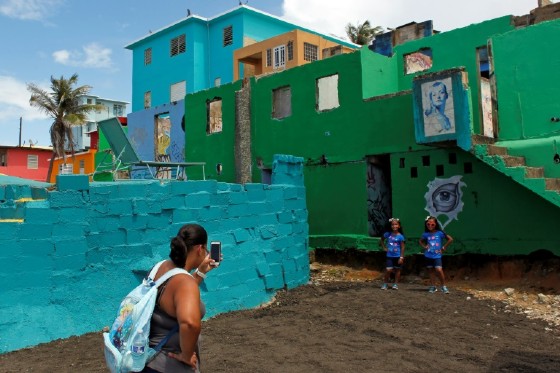 A woman takes photos in the Puerta Rican neighbourhood of La Perla