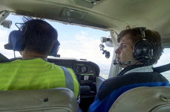Pilot Somasekhara Pemmireddy (L) and passenger Adam Nicholas sit in the cockpit during a flight over the capital in a Cessna 172 plane, at the London North Weald airfield on August 1