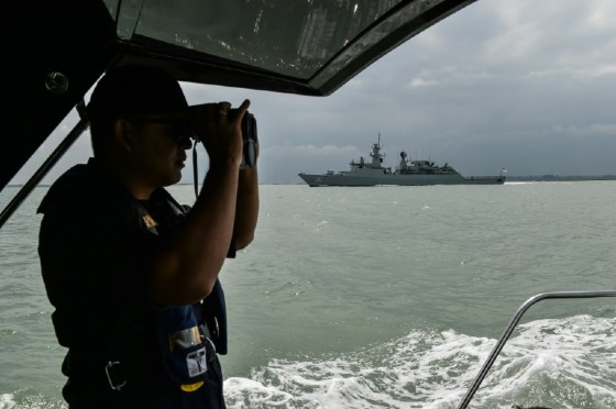 A member of the Malaysian Maritime Enforcement Agency officer scans the sea as part of the search and rescue effort