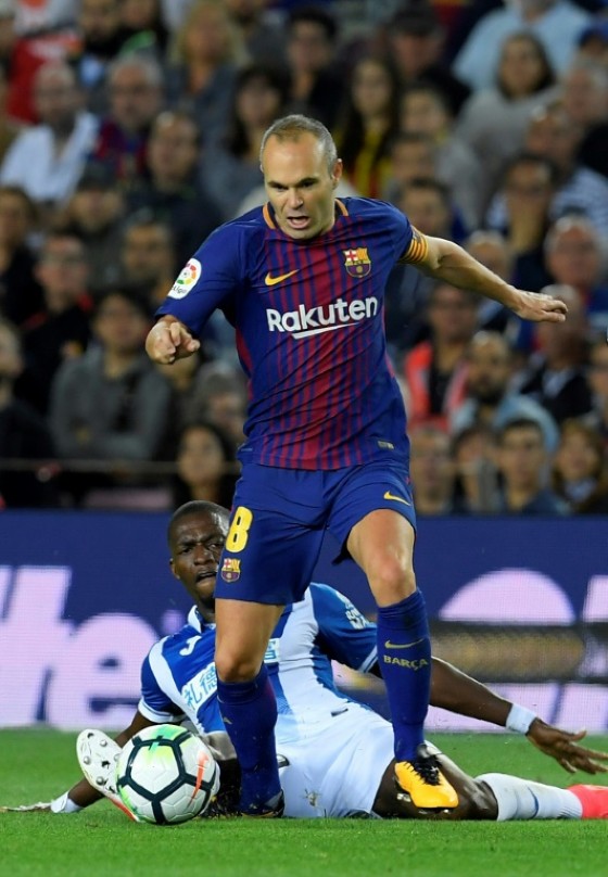 Barcelona's Andres Iniesta (up) fights for the ball with Espanyol's Papakouli Diop during their Spanish La Liga match, at the Camp Nou stadium in Barcelona, on September 9, 2017