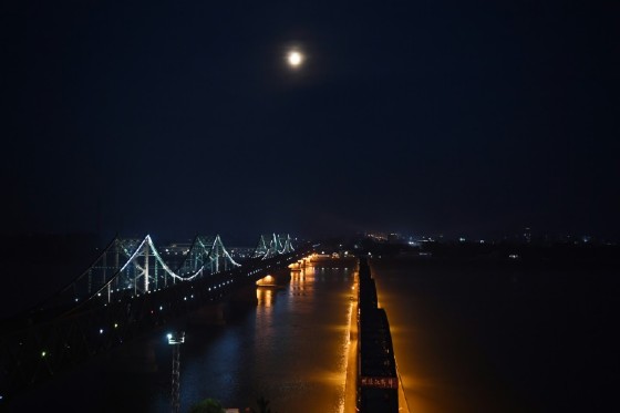 The North Korean town of Sinuiju, behind the Friendship Bridge (L) which connects Sinuiju and the the Chinese border city of Dandong