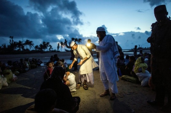 Bangladeshi officials give money for daily food ration to Rohingya Muslim refugees after they cross the border from Myanmar. More than half a million Rohingya Muslims have poured into Bangladesh in the last month