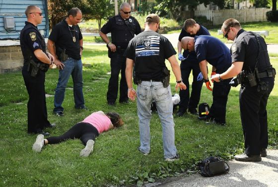 Medical workers and police treat a woman who has overdosed on heroin, the second case in a matter of minutes, on July 14, 2017 in Warren, Ohio