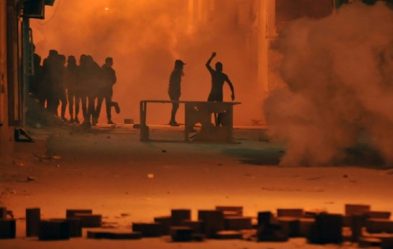 Protestors throw stones towards security forces in Tunis' Djebel Lahmer district early on January 10, 2018 after price hikes ignited demonstrations