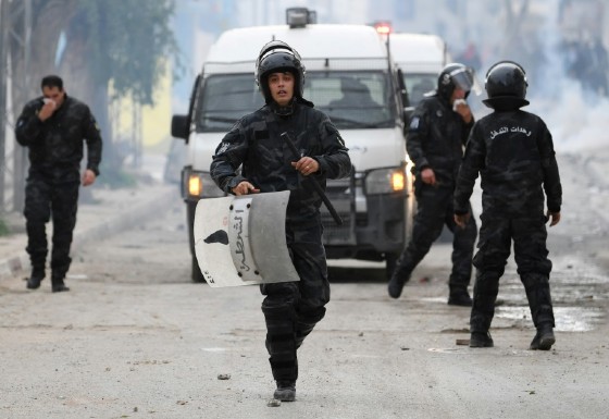 Tunisian security forces stand amid tear gas during clashes with protesters in the town of Tebourba on January 9, 2018