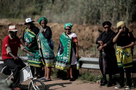 Women wrap themselves in ANC flags to pay their respects to the former wife of Nelson Mandela