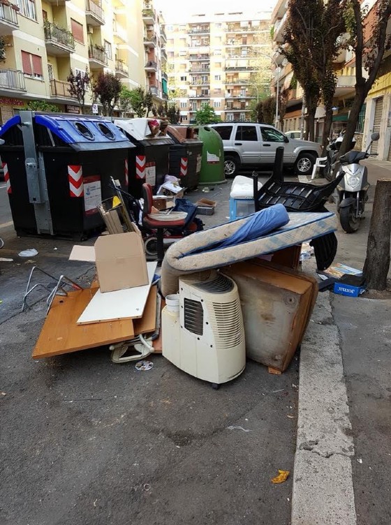 Cumuli di rifiuti vicino ai cassonetti in una delle vie del Municipio XI