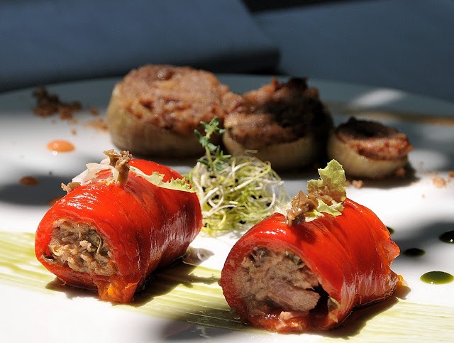 I peperoni arrostiti, spellati e ripieni di ventresca di tonno, accompagnano le dolci cipolli eporediesi farcite di amaretti e uvetta