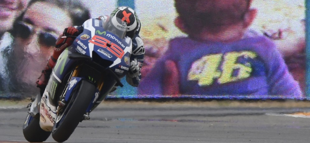 Jorge Lorenzo passa davanti a un cartello dei tifosi di Valentino Rossi ad Aragon