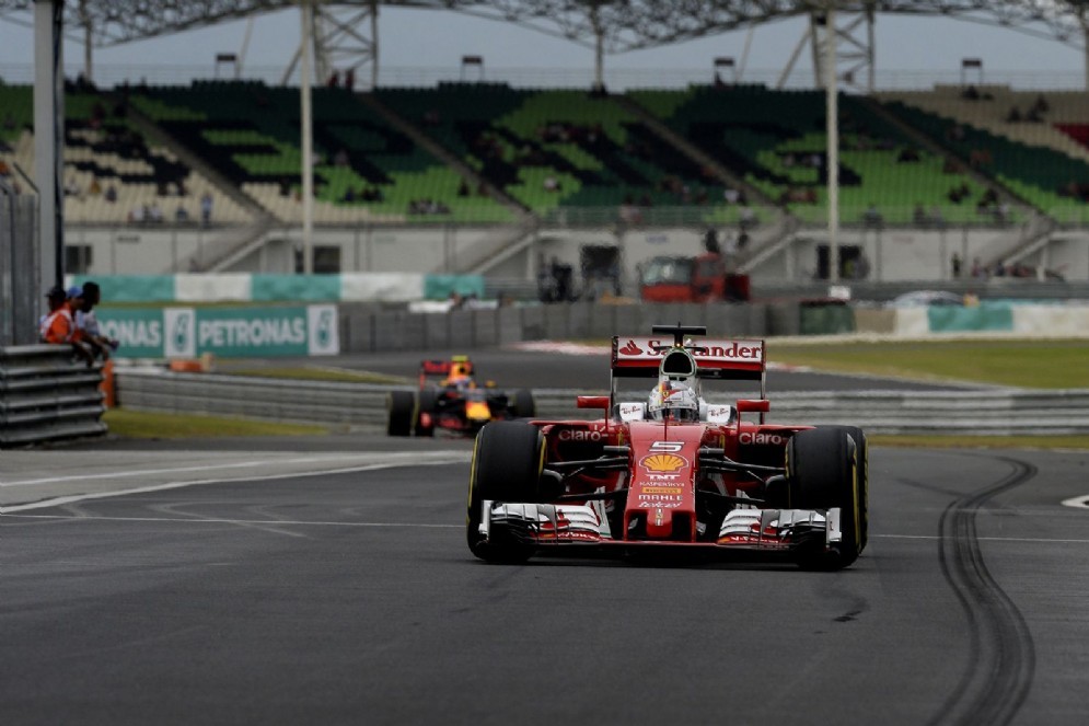 Sebastian Vettel rientra ai box davanti a una Red Bull