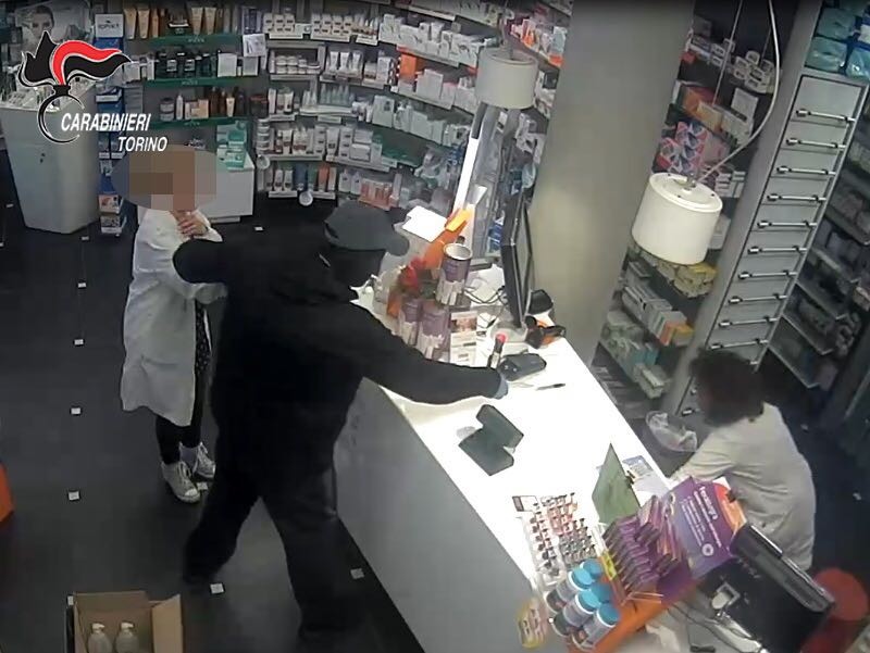 Il rapinatore in azione dentro la farmacia