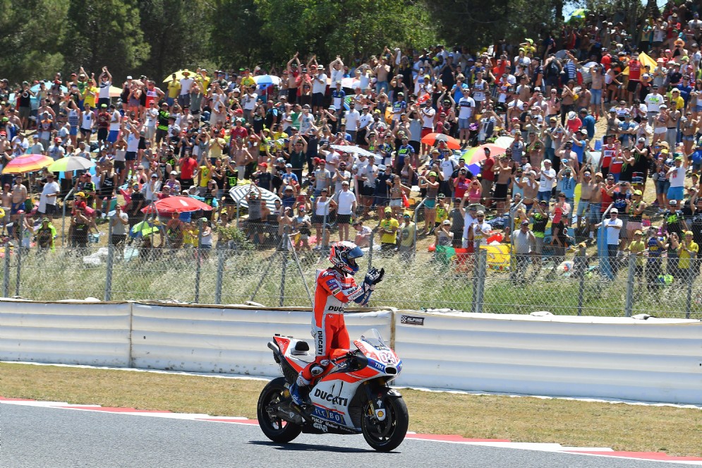 Il ducatista saluta il pubblico catalano dopo aver tagliato il traguardo per primo