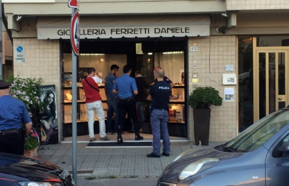 Inquirenti all'esterno della gioielleria Ferretti a Pisa dove un uomo  morto durante una rapina