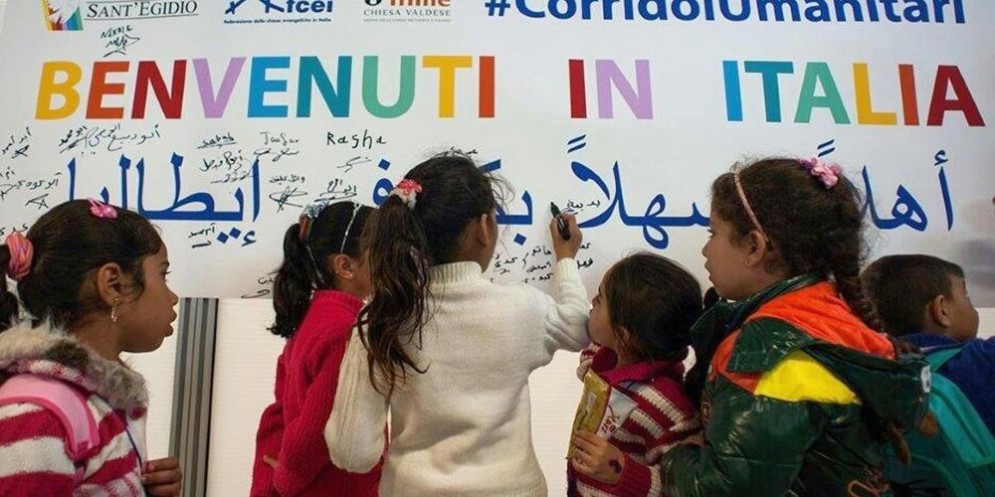 Piccoli migranti accolti da uno striscione di benvenuto