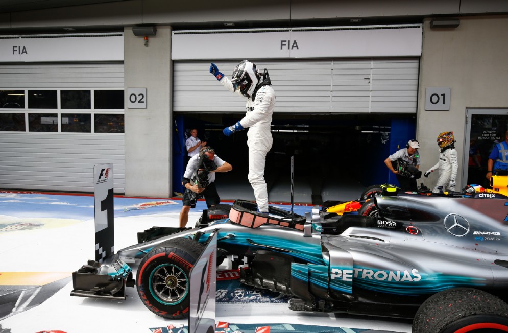 Bottas a braccia alzate sulla sua Mercedes dopo la vittoria al Red Bull Ring
