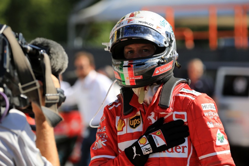 Vettel saluta le telecamere dopo essere sceso dalla sua macchina