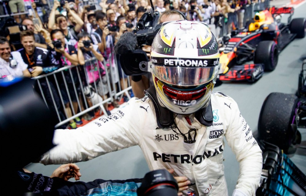 Hamilton festeggia con il team Mercedes dopo aver vinto la gara