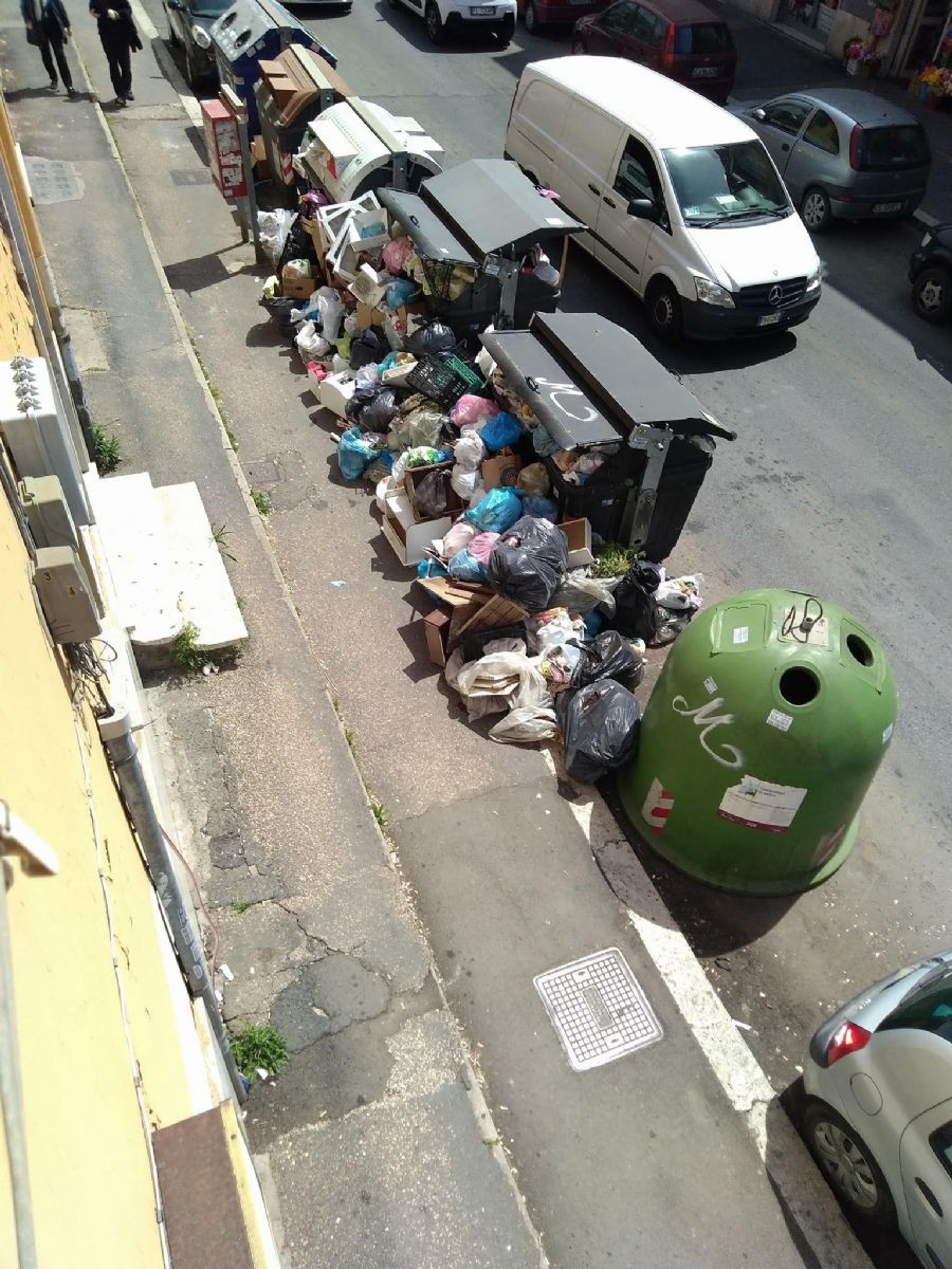 Cumuli di rifiuti vicino ai cassonetti in una delle vie del Municipio XI