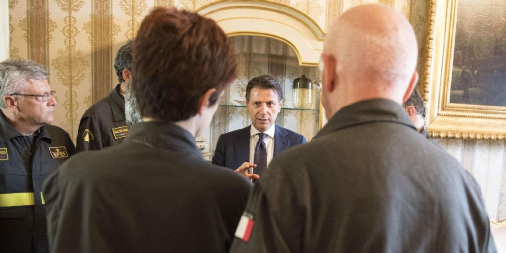 Il premier Giuseppe Conte con alcuni Vigili del Fuoco a Genova