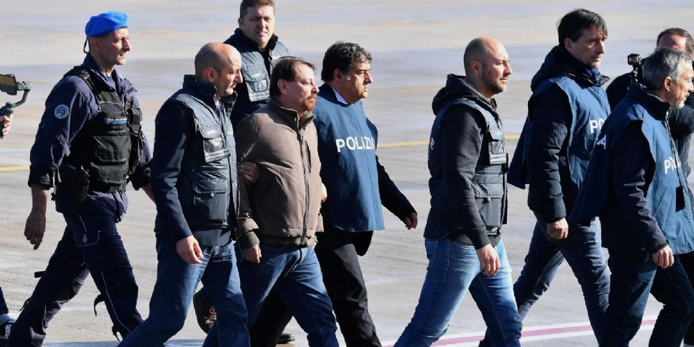 Cesare Battisti mentre atterra all'aeroporto di Ciampino scortato dagli agenti della Polizia